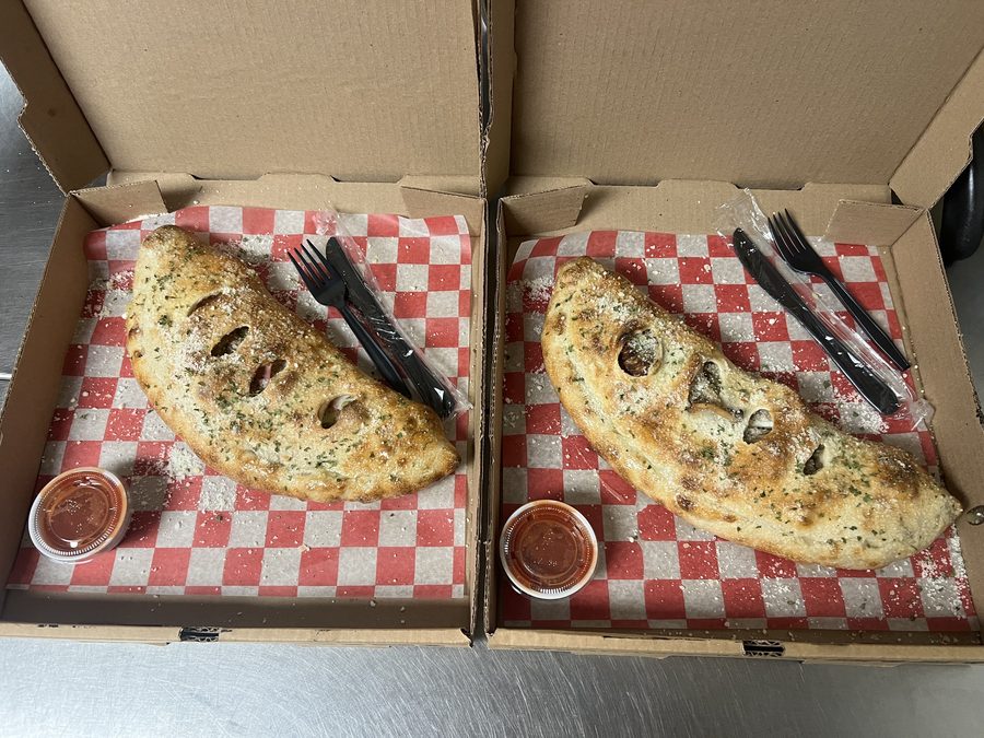 Two calzones with marinara dipping sauce